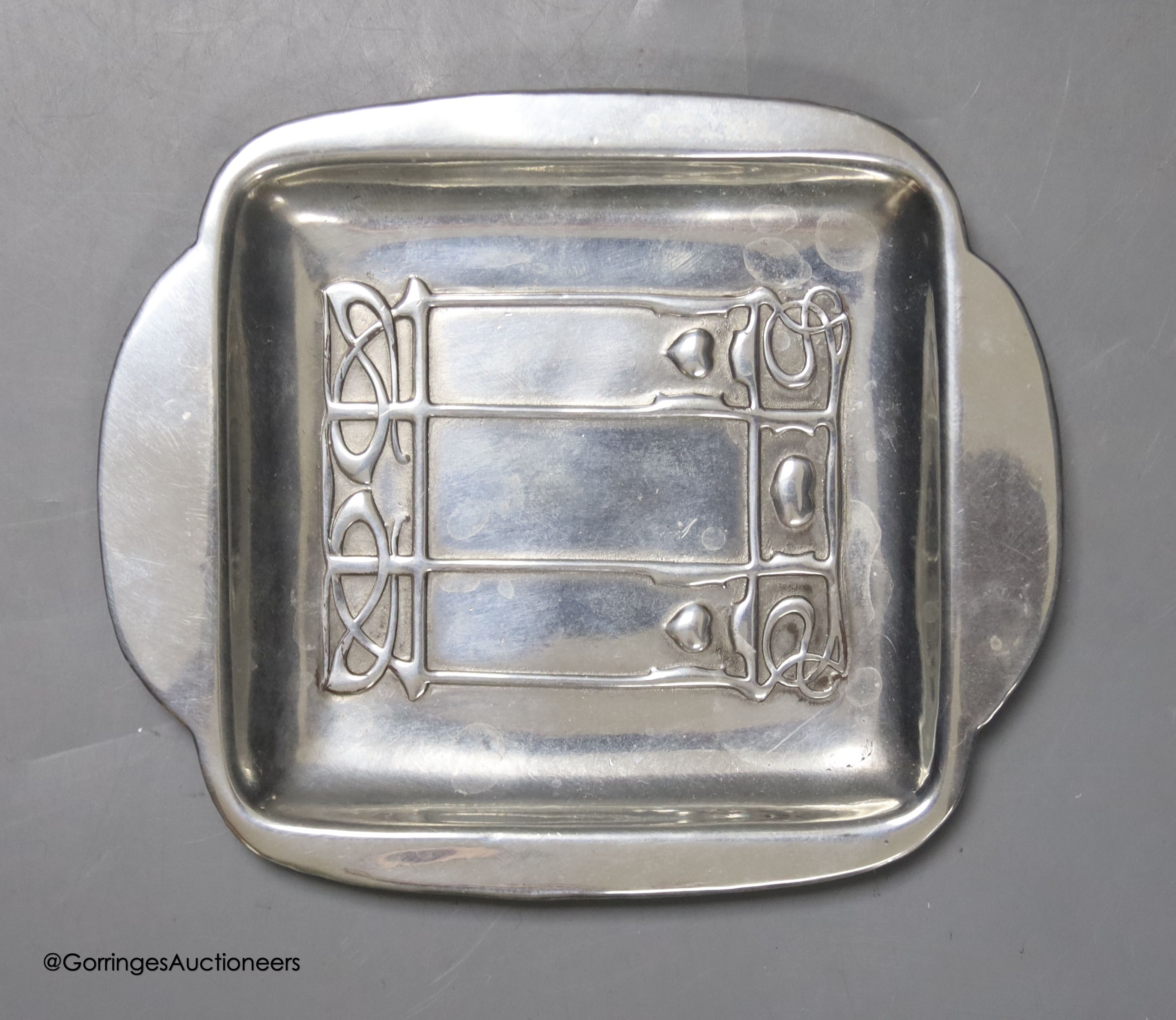 A Liberty & Co Tudric pewter pin dish, a Tudric covered jug and a pewter candleholder